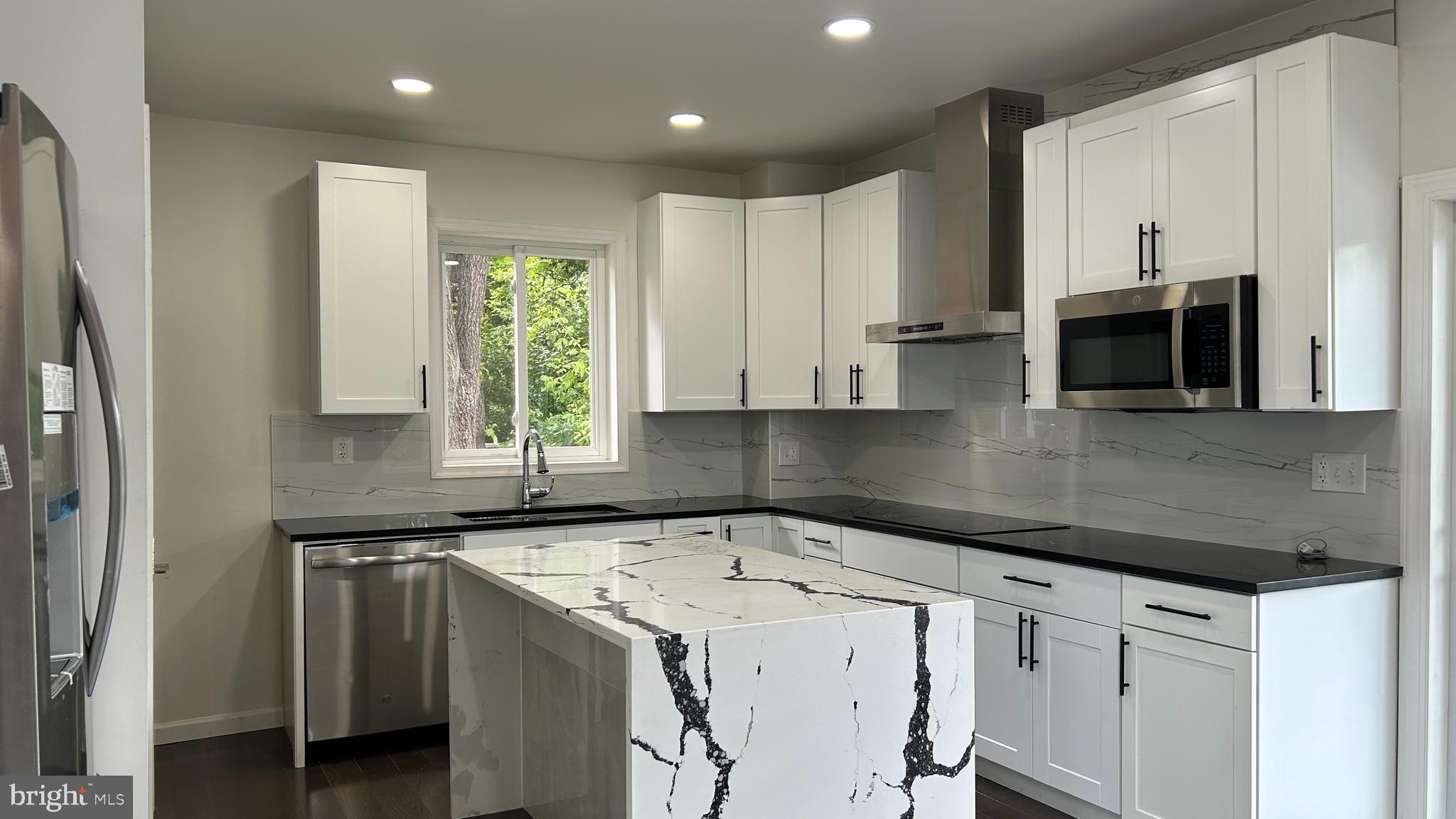 a kitchen with a sink a microwave and cabinets