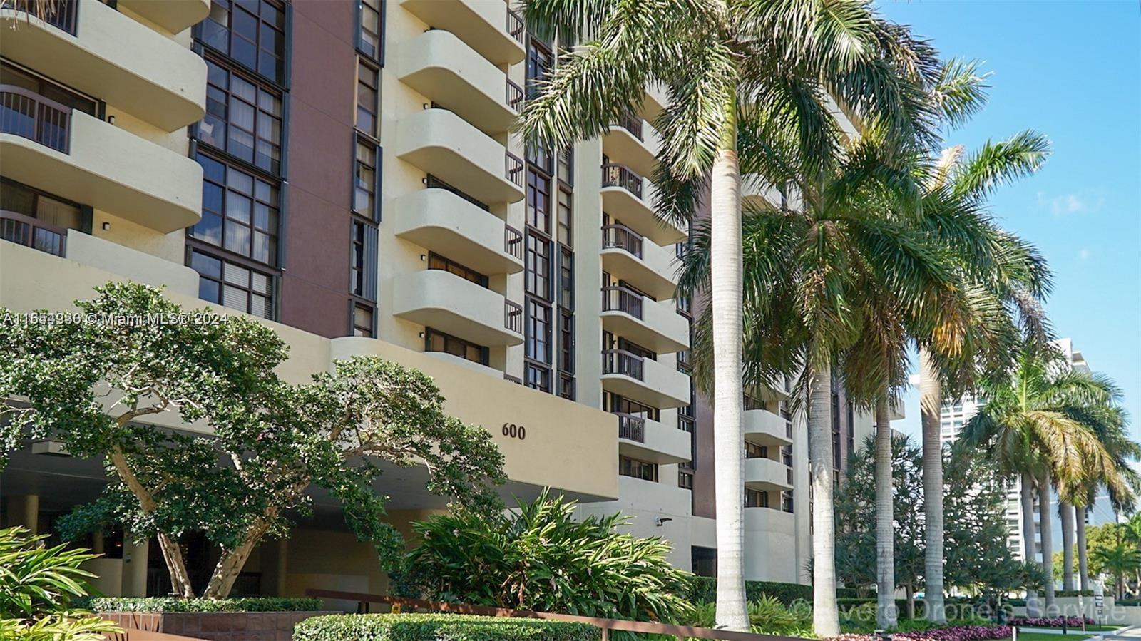 a front view of multi story residential apartment building with a yard