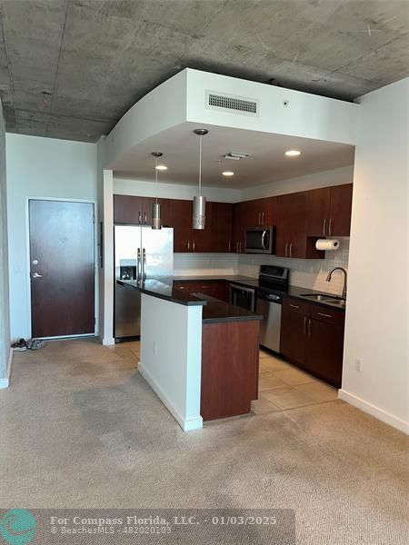 a kitchen with stainless steel appliances granite countertop a stove a sink and a refrigerator