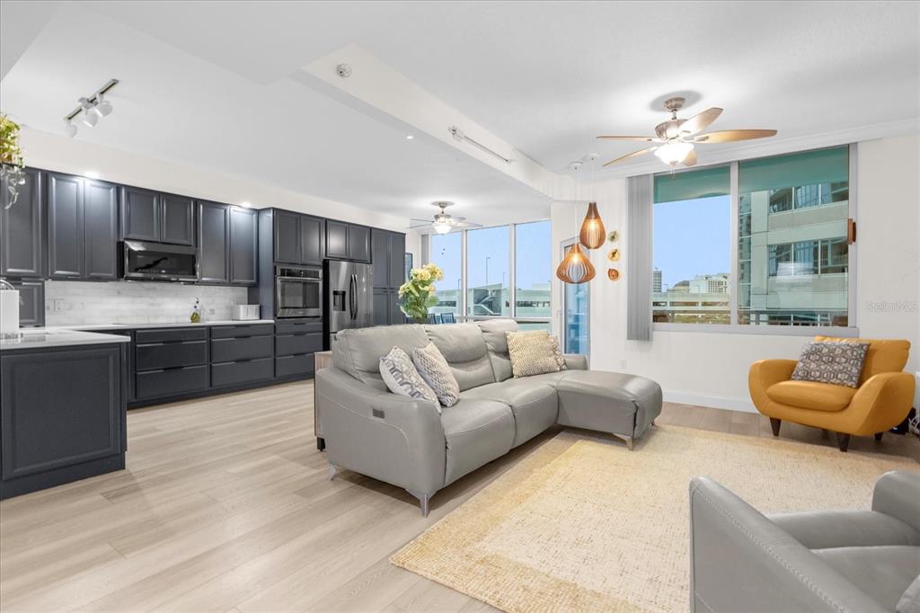 a living room with furniture kitchen and a chandelier