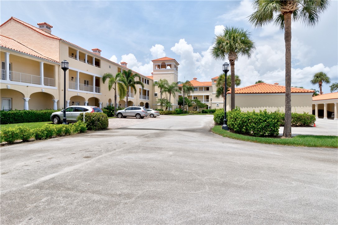 a front view of multiple houses with palm trees