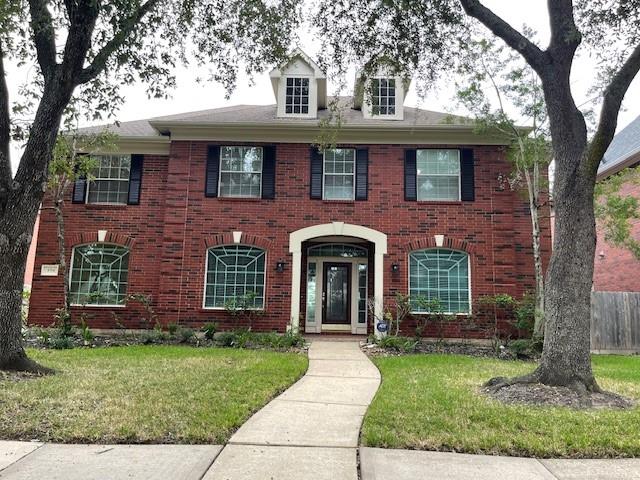 front view of a brick house with a yard