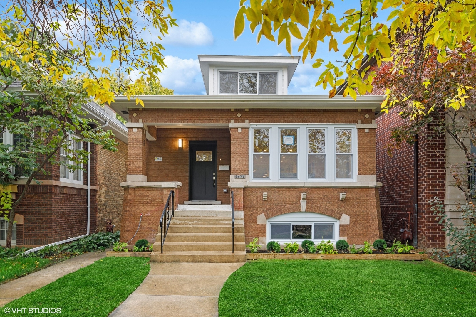 a front view of a house with a garden and yard