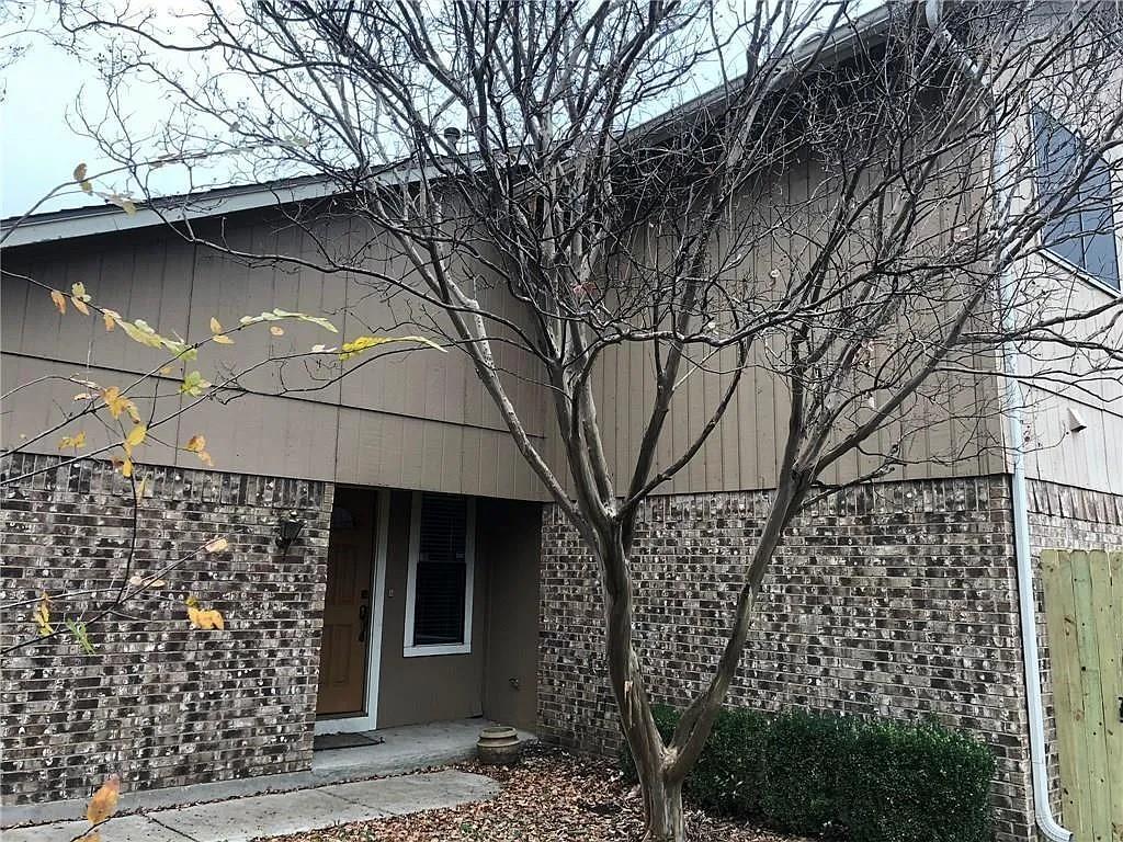 a front view of a house with a tree