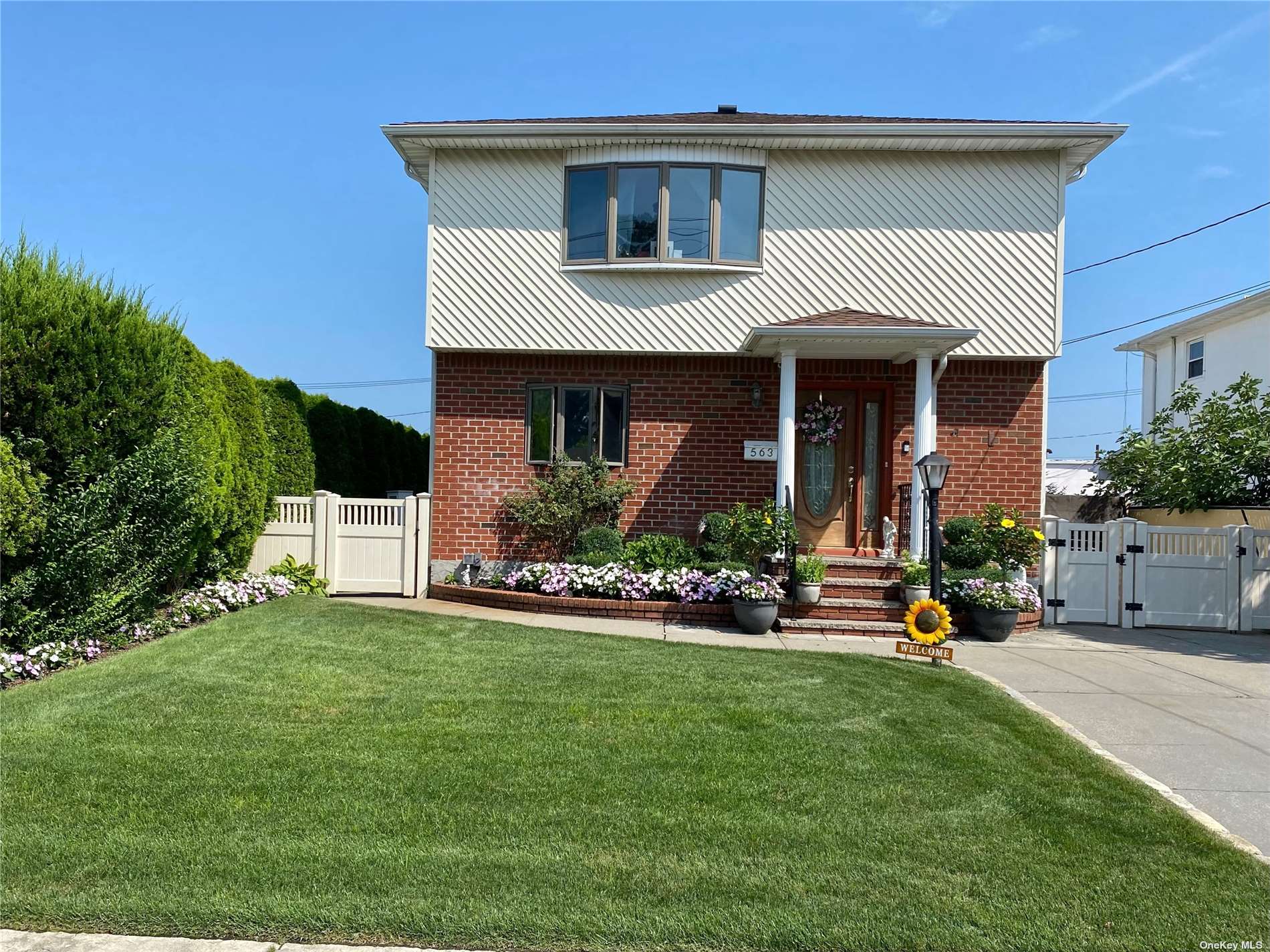 a front view of a house with a yard and potted plants