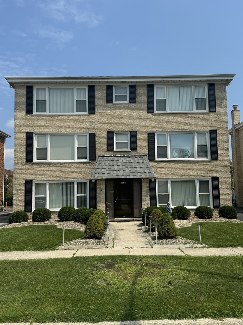 a front view of a residential apartment building with a yard