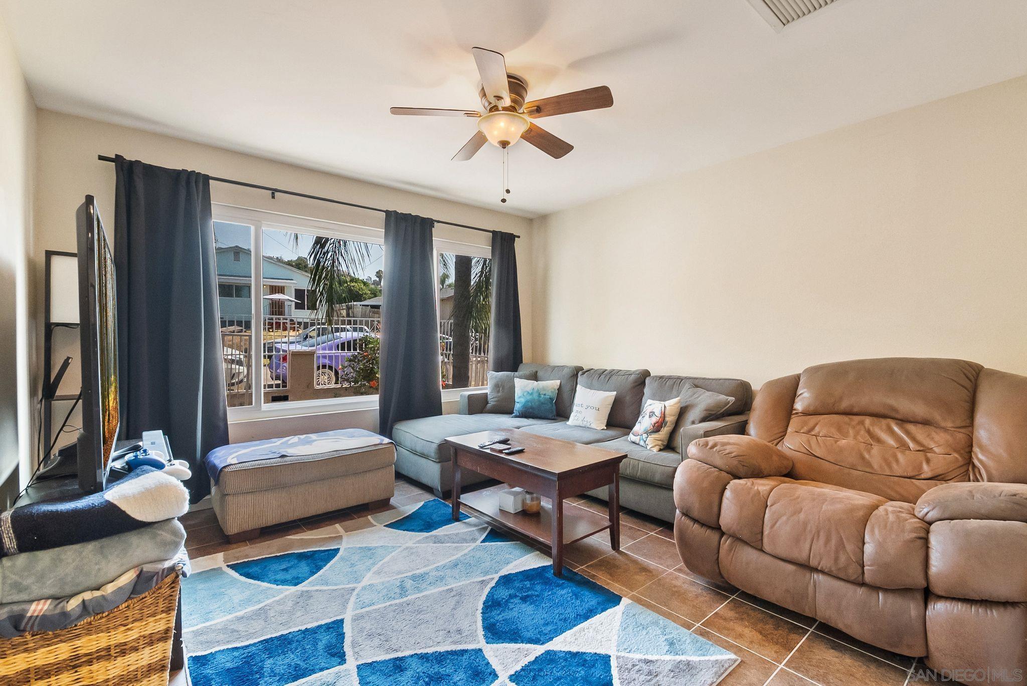 a living room with furniture ceiling fan and a rug