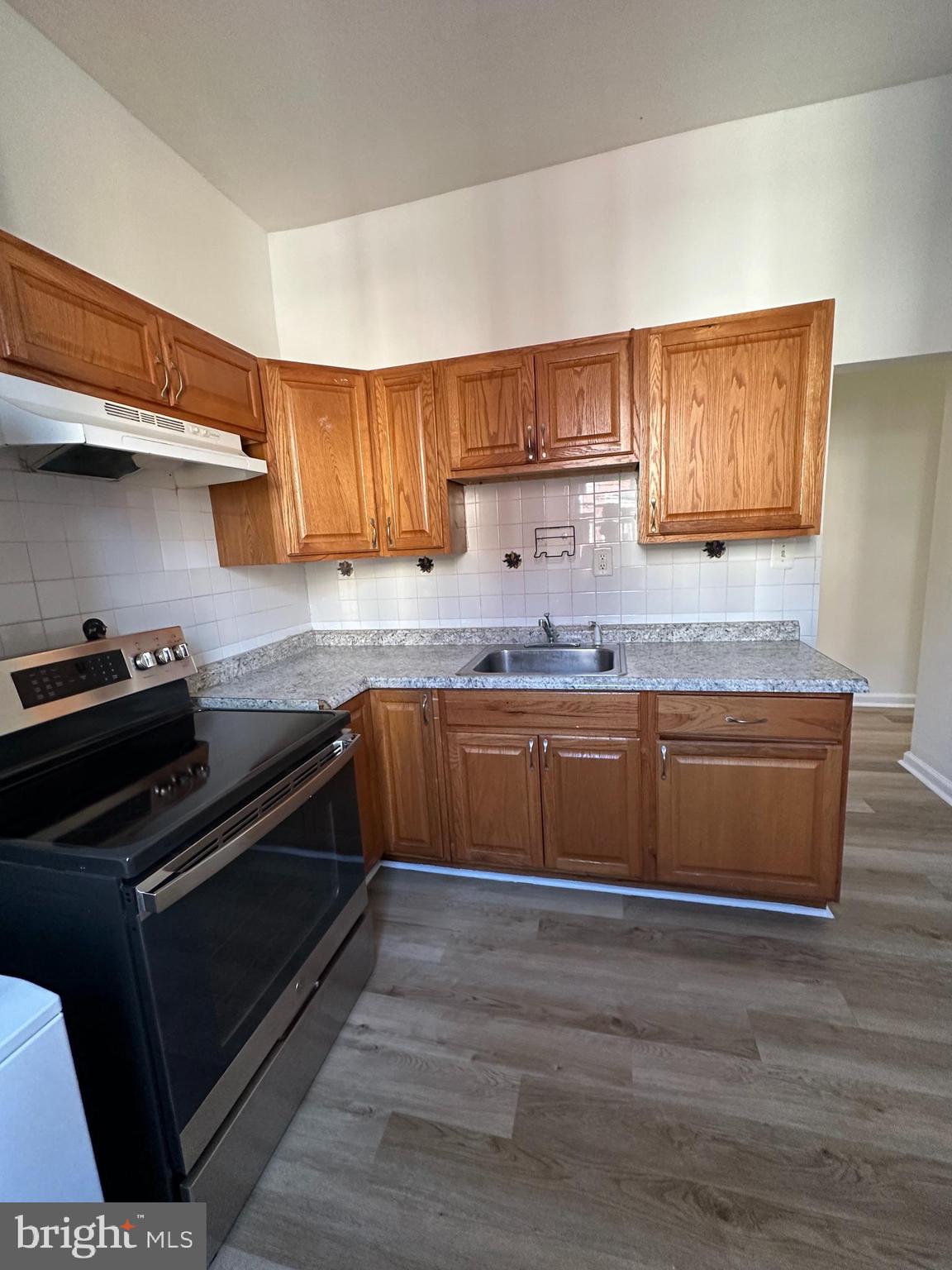 a kitchen with granite countertop a stove and cabinets