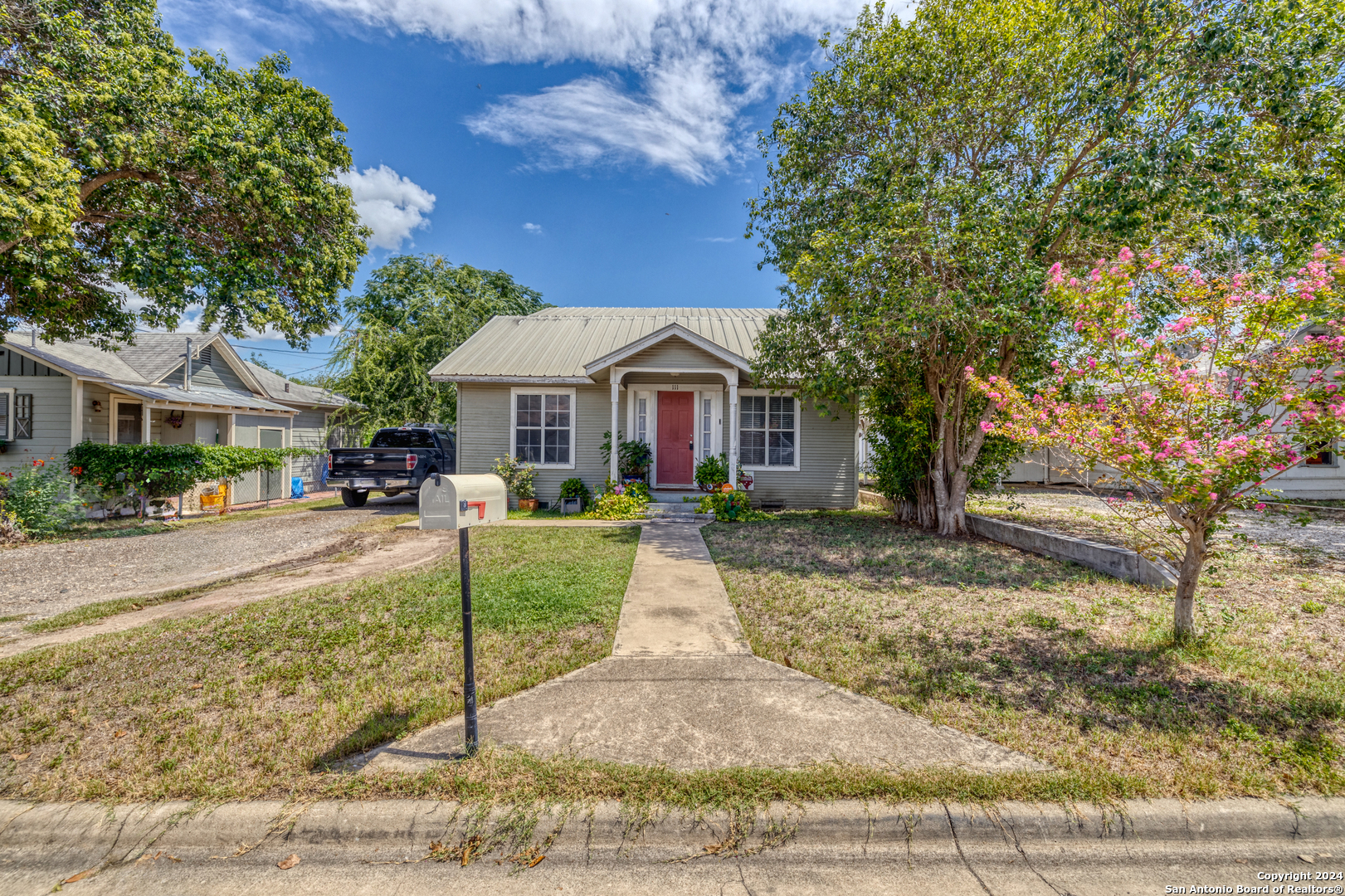 a front view of a house with a yard and tree s