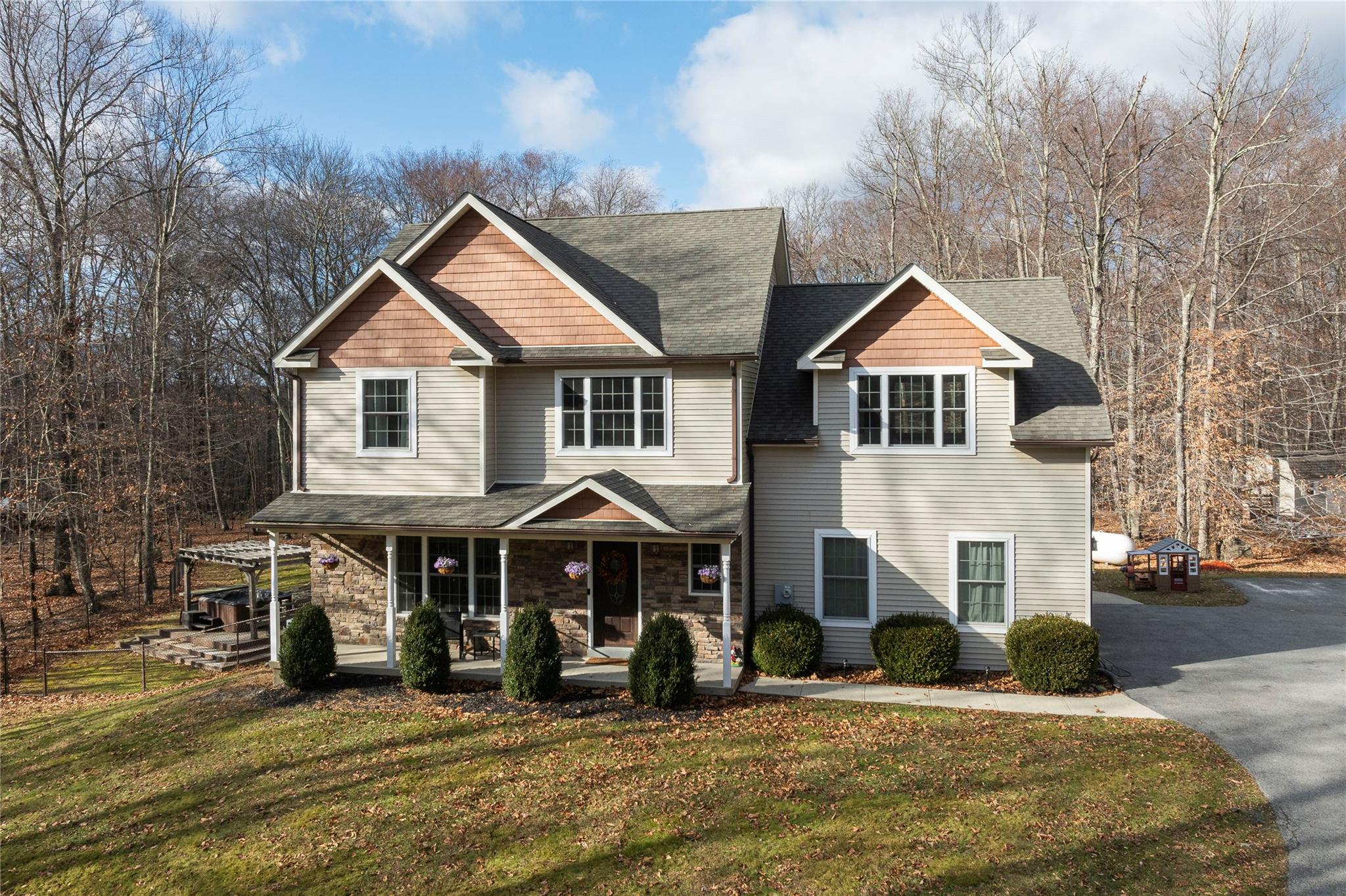 View of front of home with covered porch and a front lawn