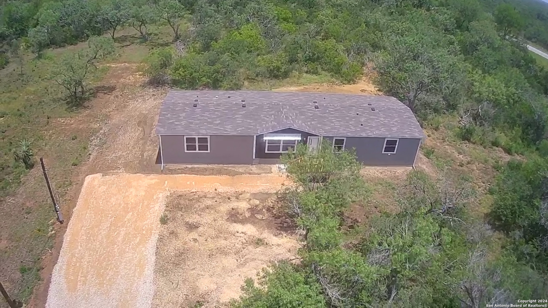 a aerial view of a house with yard and green space