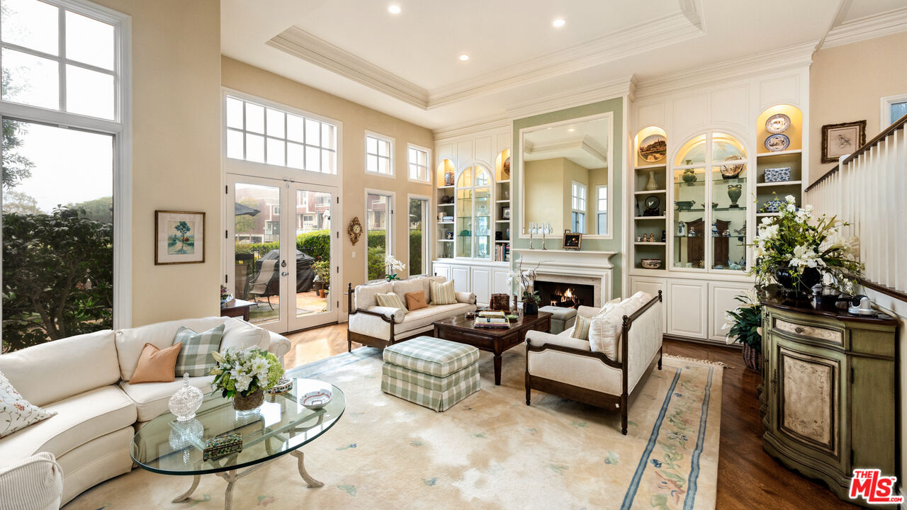 a living room with fireplace furniture and floor to ceiling windows