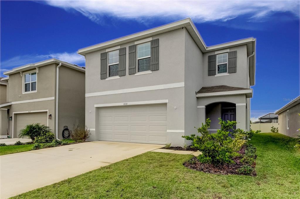 a front view of a house with a yard and garage