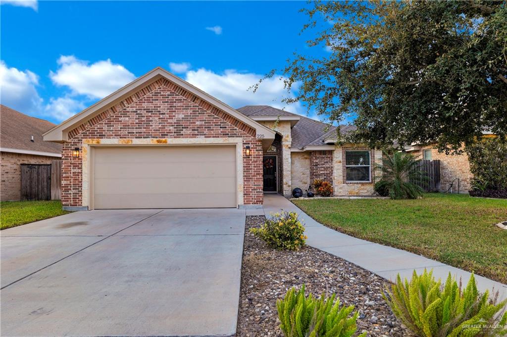 View of front of home featuring a front yard and a garage