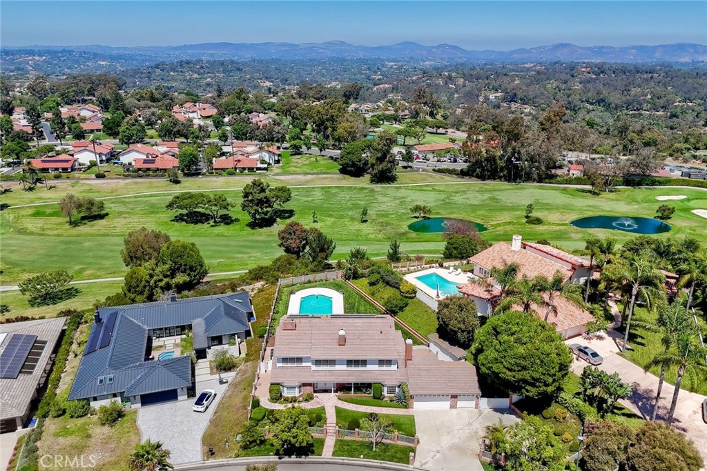 an aerial view of a houses with a yard and lake view