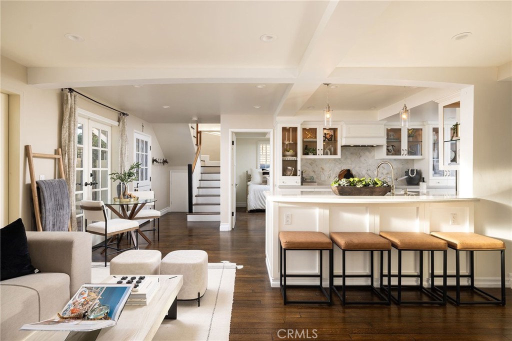 a living room with furniture wooden floor and a kitchen view