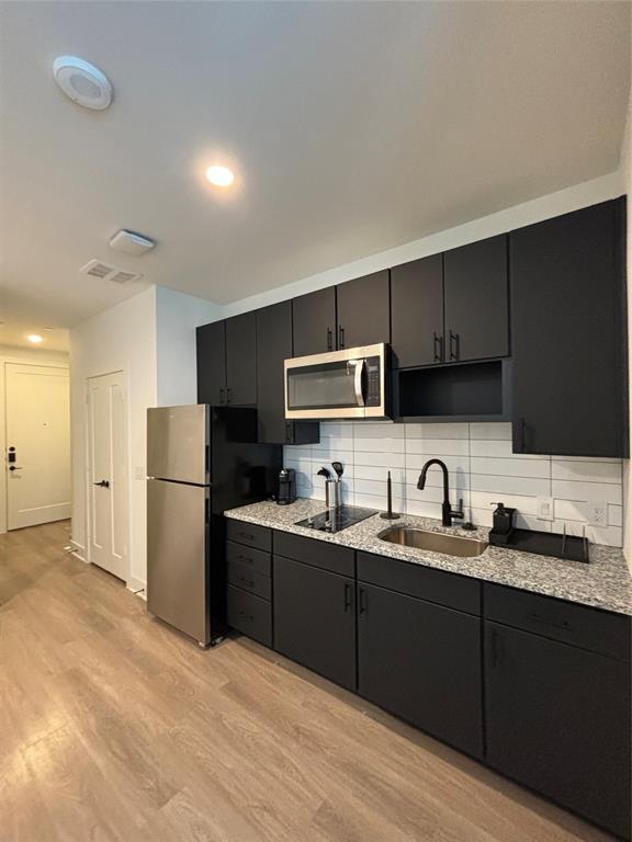 a kitchen with stainless steel appliances granite countertop a sink refrigerator and cabinets