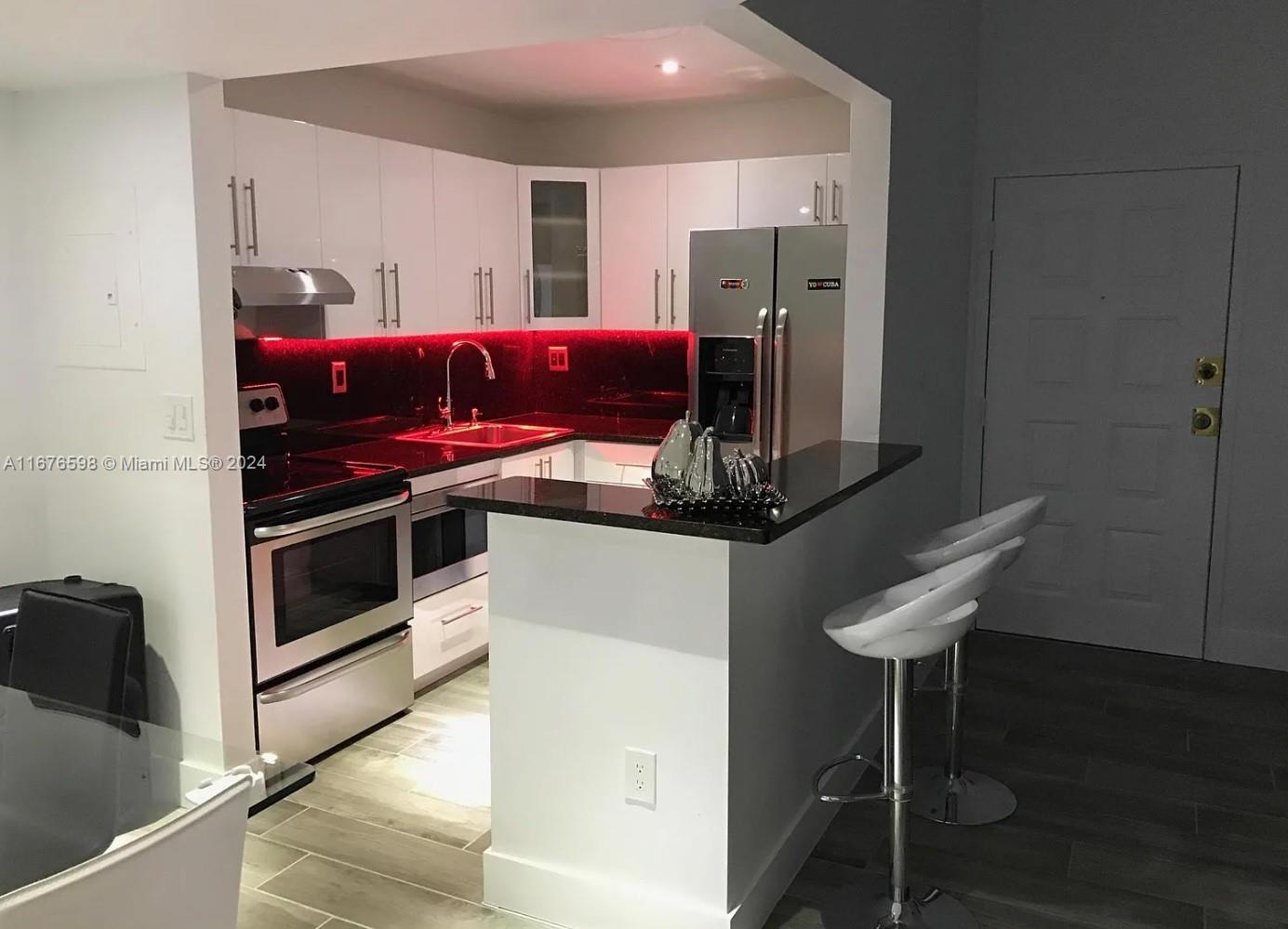 a kitchen with stainless steel appliances kitchen island granite countertop a stove and a refrigerator