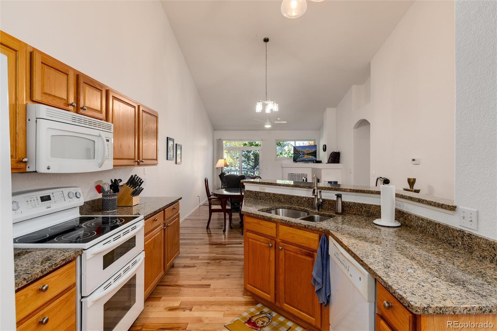 a kitchen with stainless steel appliances granite countertop a stove a sink and a microwave