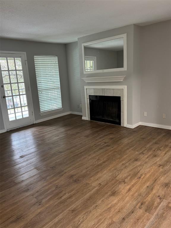 a view of empty room with wooden floor and fireplace