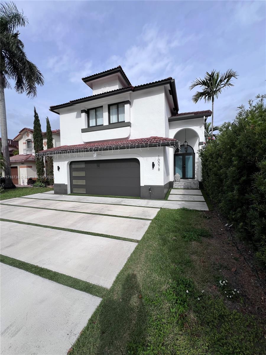 a front view of a house with a yard and garage