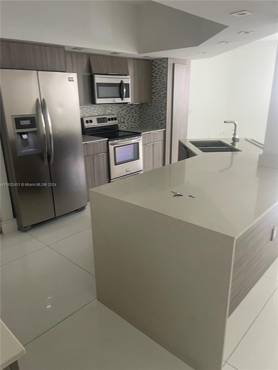 a kitchen with stainless steel appliances a refrigerator and a stove