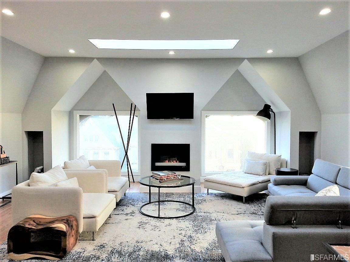 a living room with furniture a flat screen tv and a fireplace