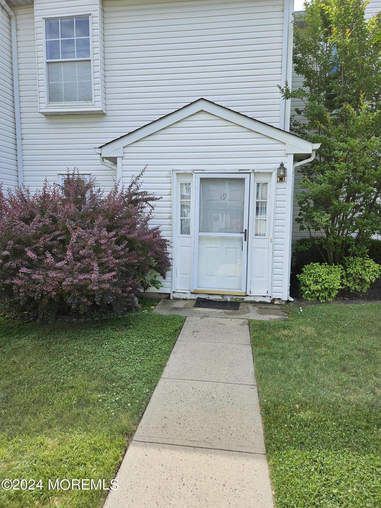 a front view of a house with a garden and plants