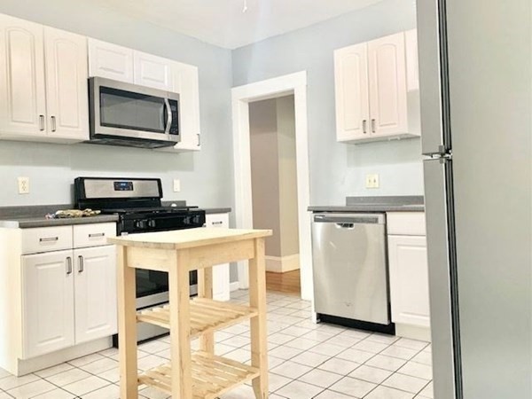 a kitchen with stainless steel appliances a refrigerator sink and white cabinets