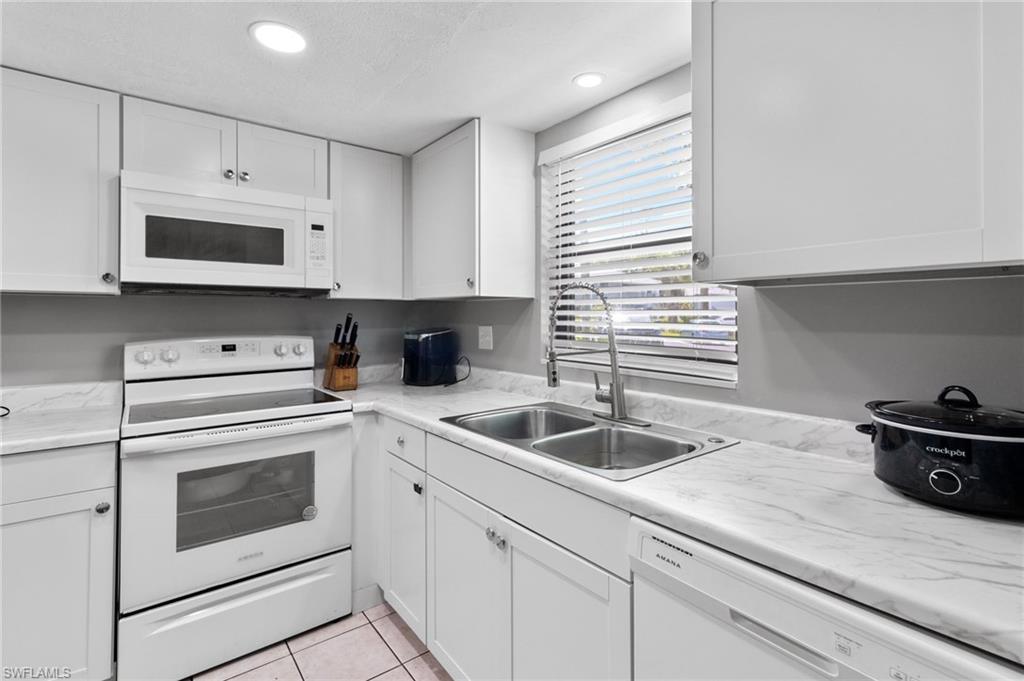 a kitchen with cabinets stainless steel appliances a sink and a window