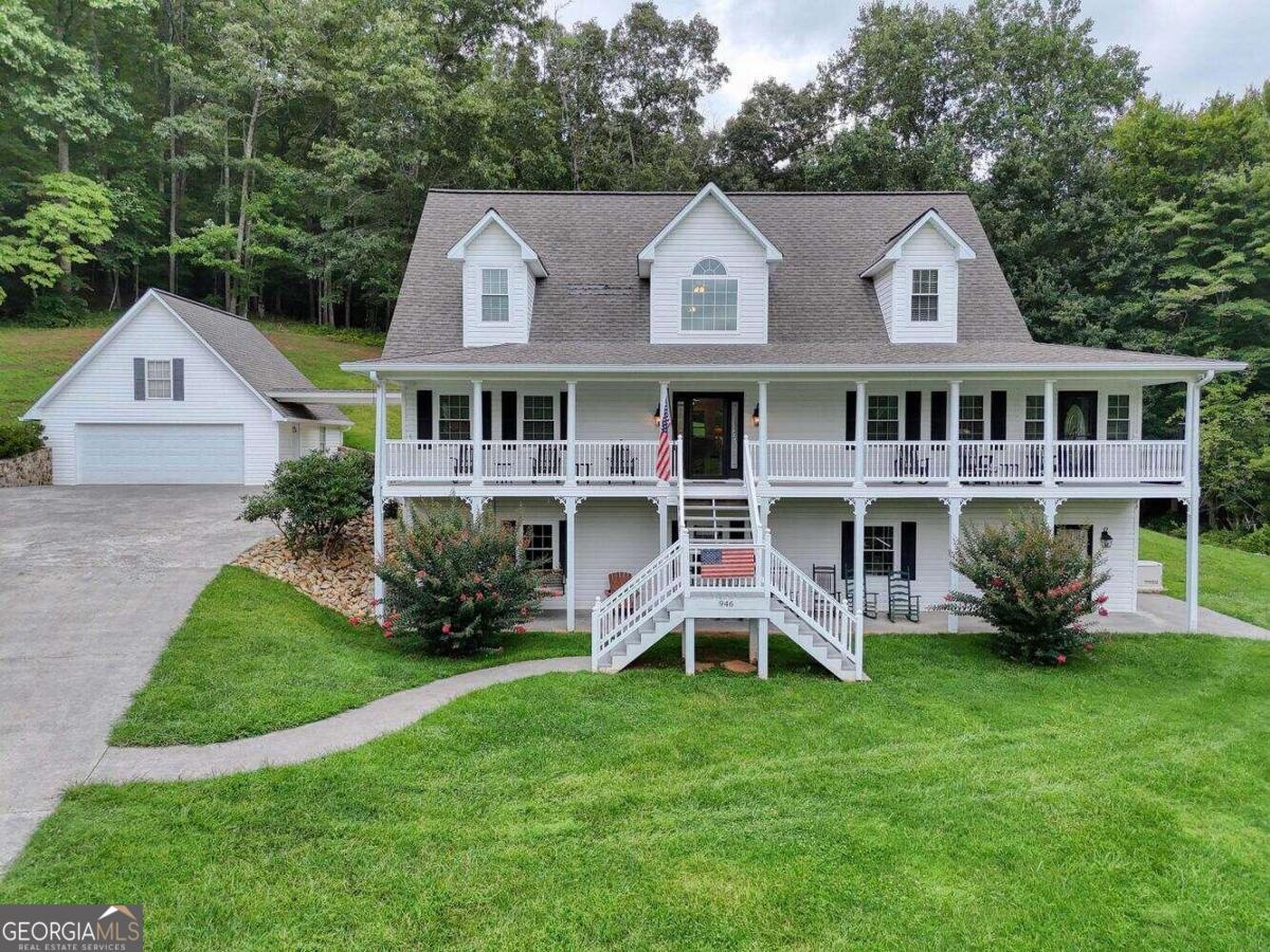 a front view of a house with a yard and green space