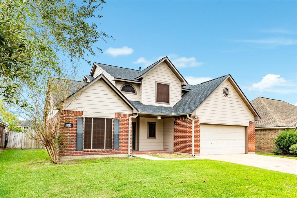 a front view of a house with a yard and trees