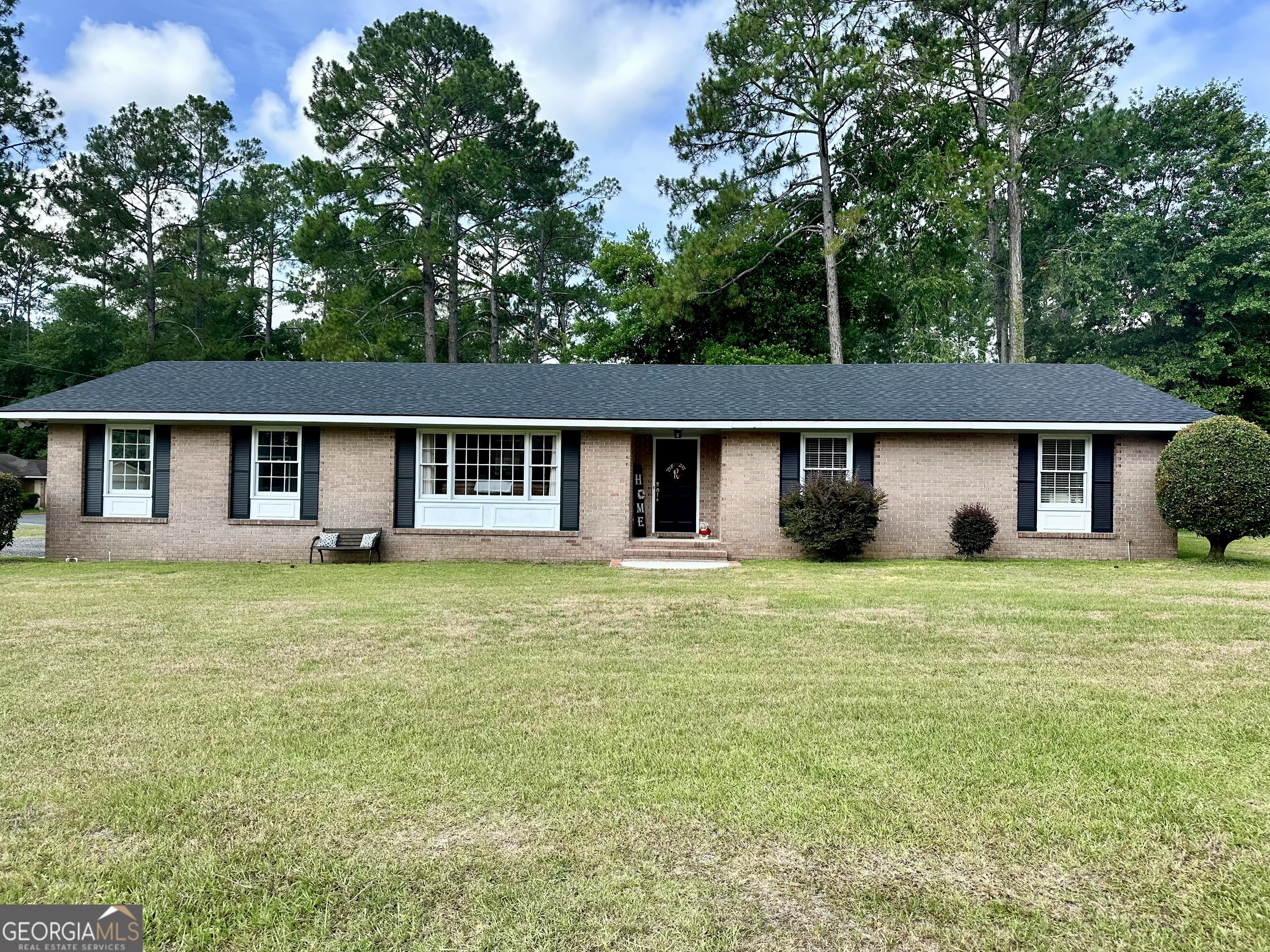 a front view of a house with a garden