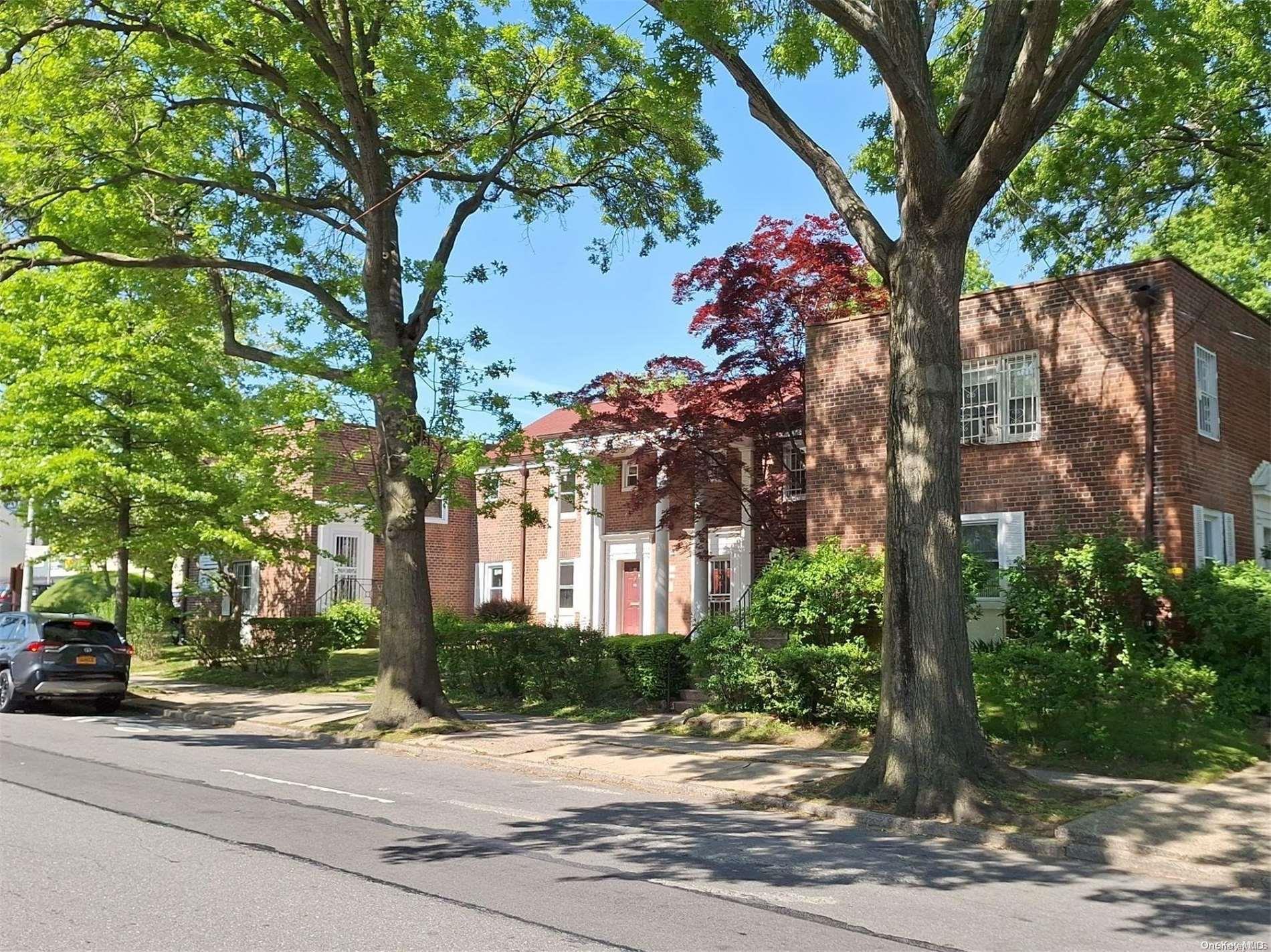 a front view of a house with a tree