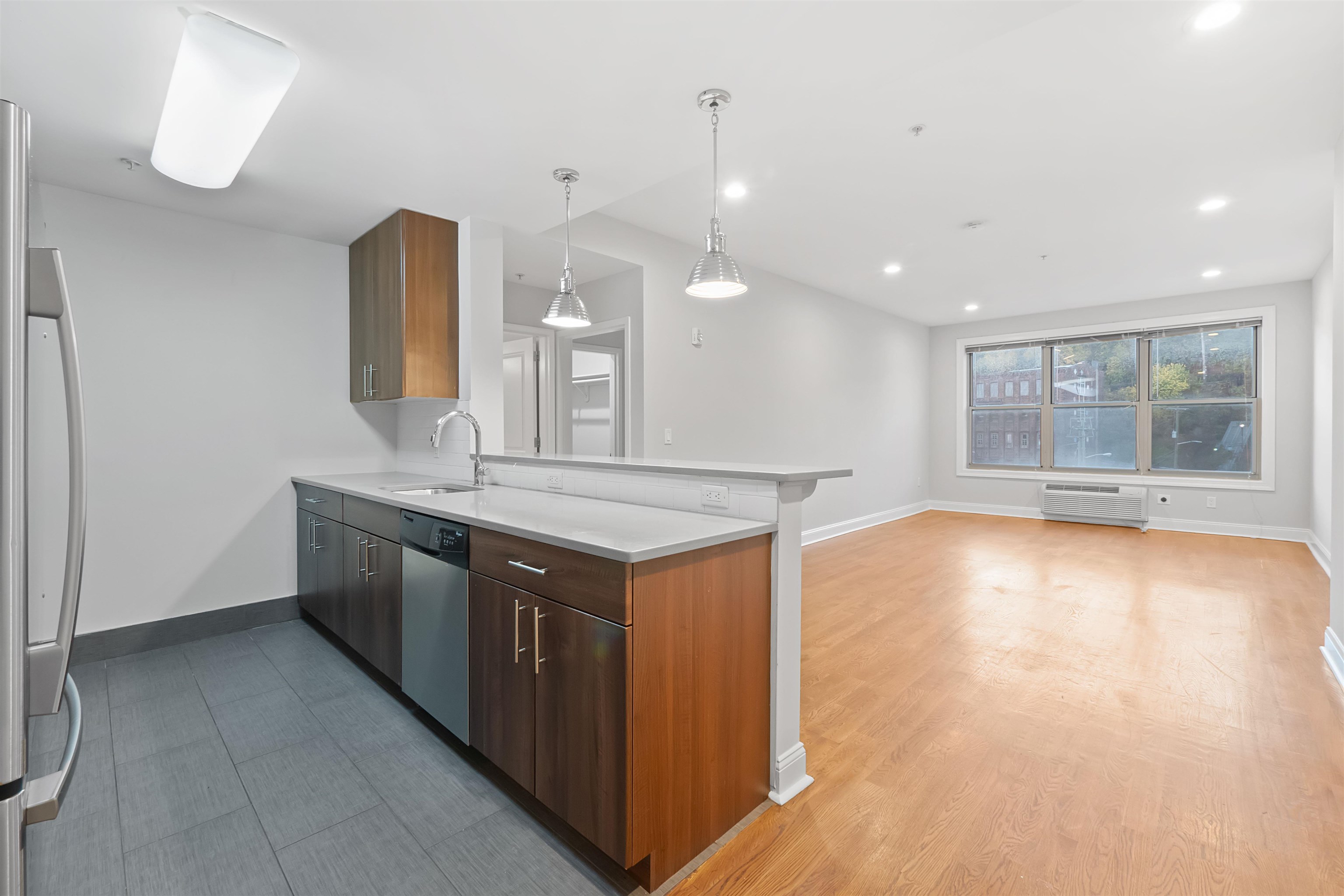 a kitchen with stainless steel appliances granite countertop a sink and a large window