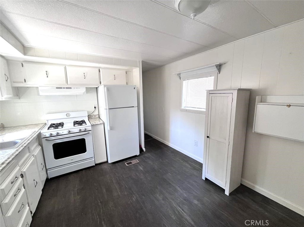 a kitchen with a white stove top oven and refrigerator