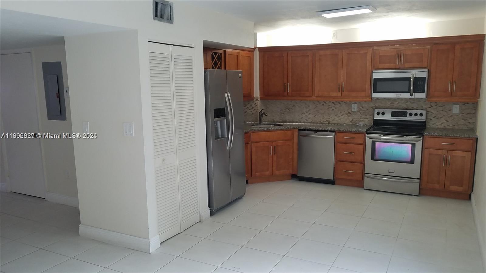 a kitchen with stainless steel appliances granite countertop a refrigerator and a stove top oven