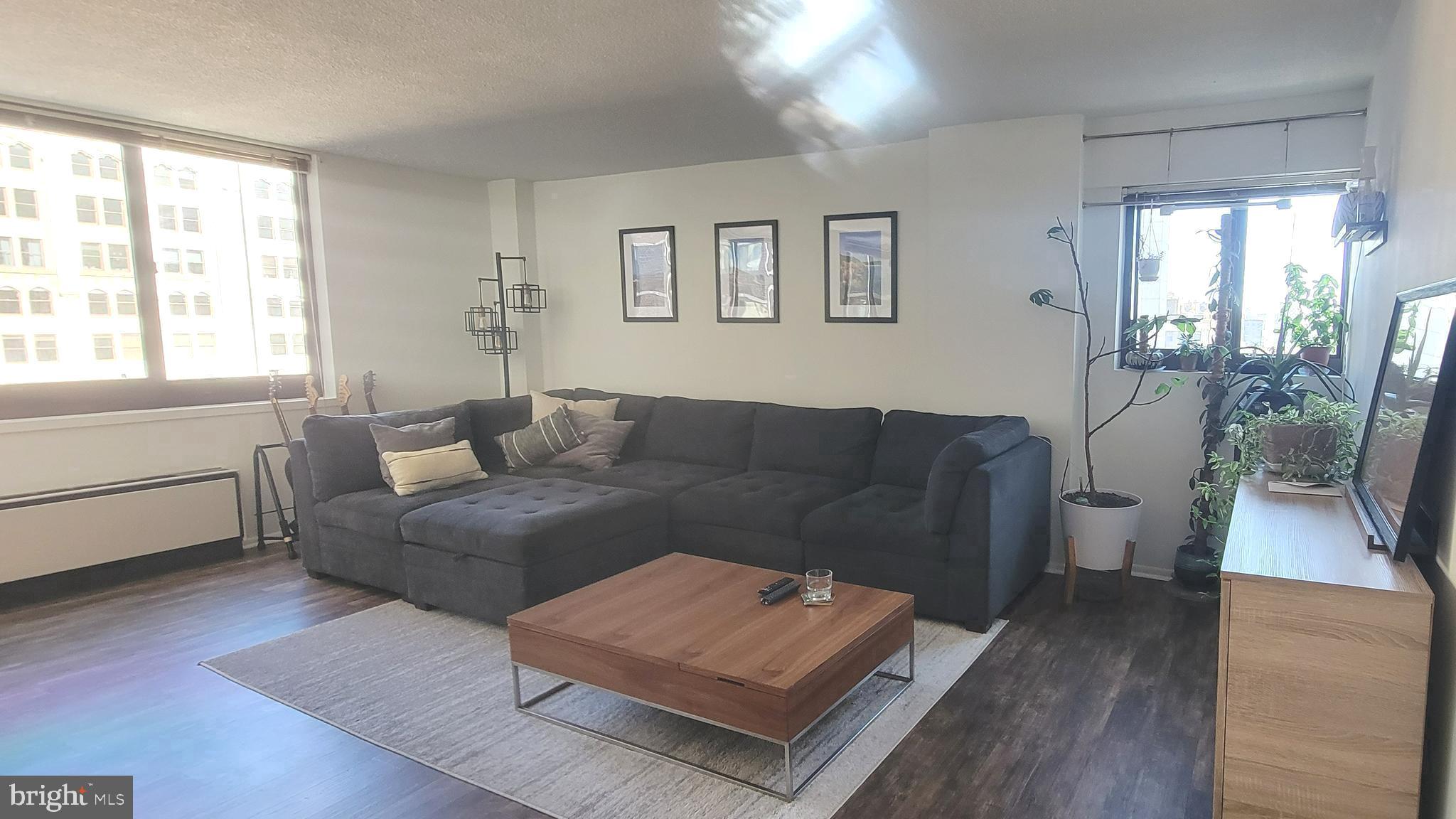 a living room with furniture and a wooden floor