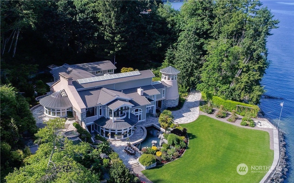 an aerial view of a house with garden space and trees all around