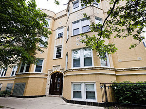 a front view of a building with a tree