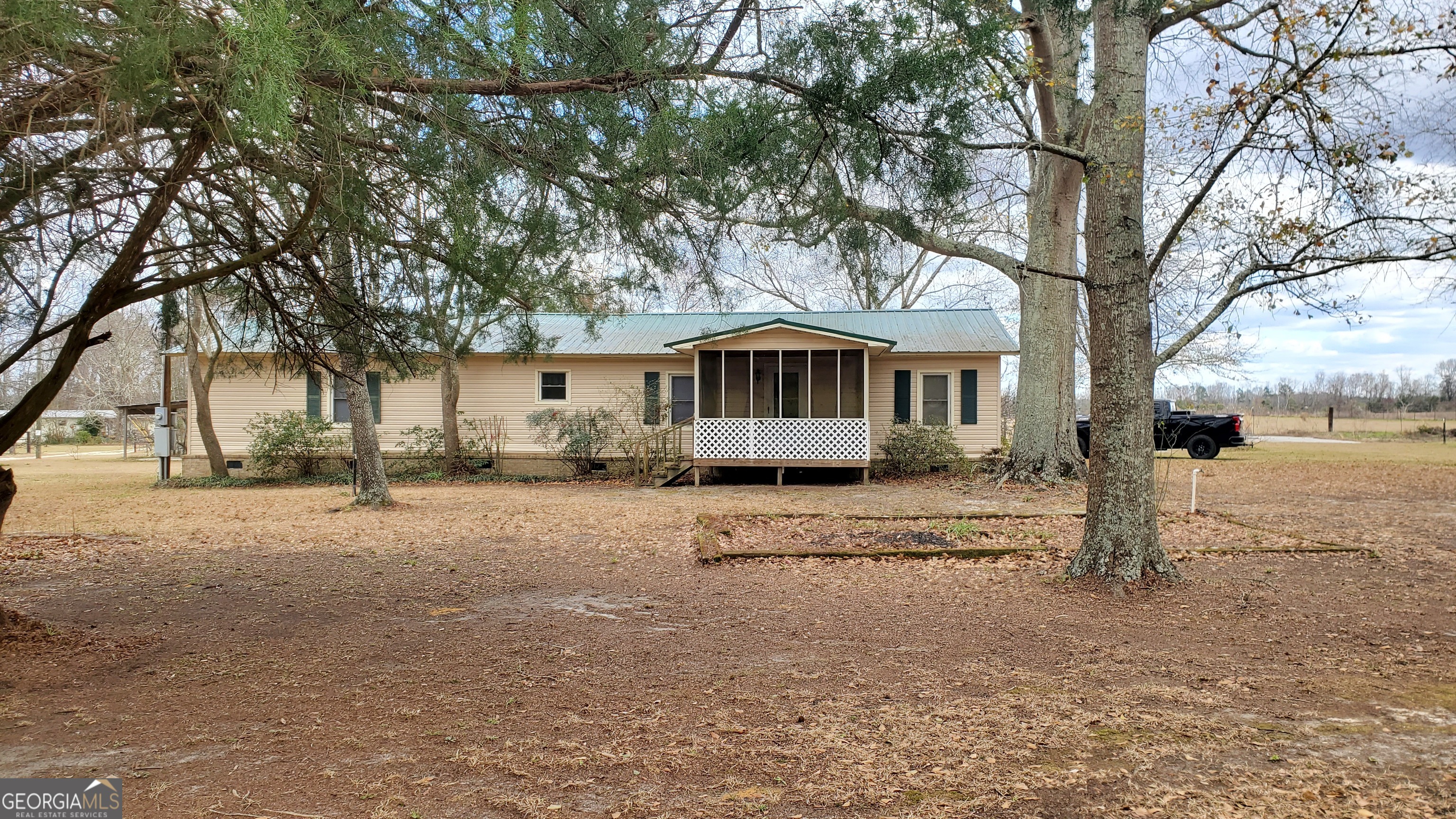 a view of a large house with a large tree and wooden fence