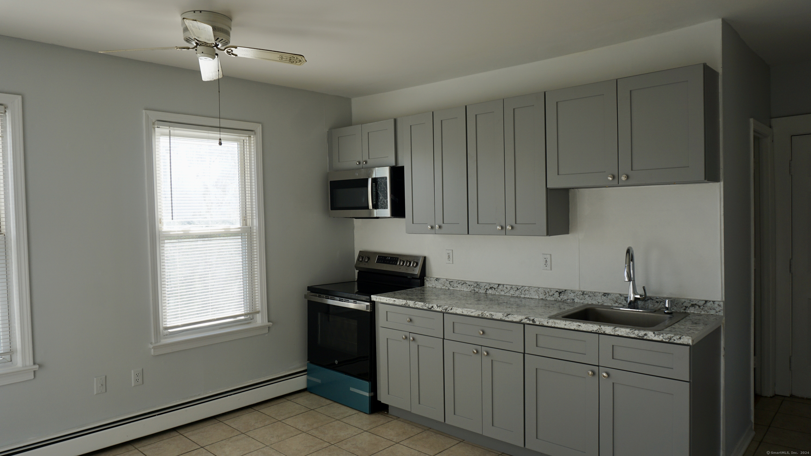 a kitchen with granite countertop a sink stainless steel appliances and cabinets