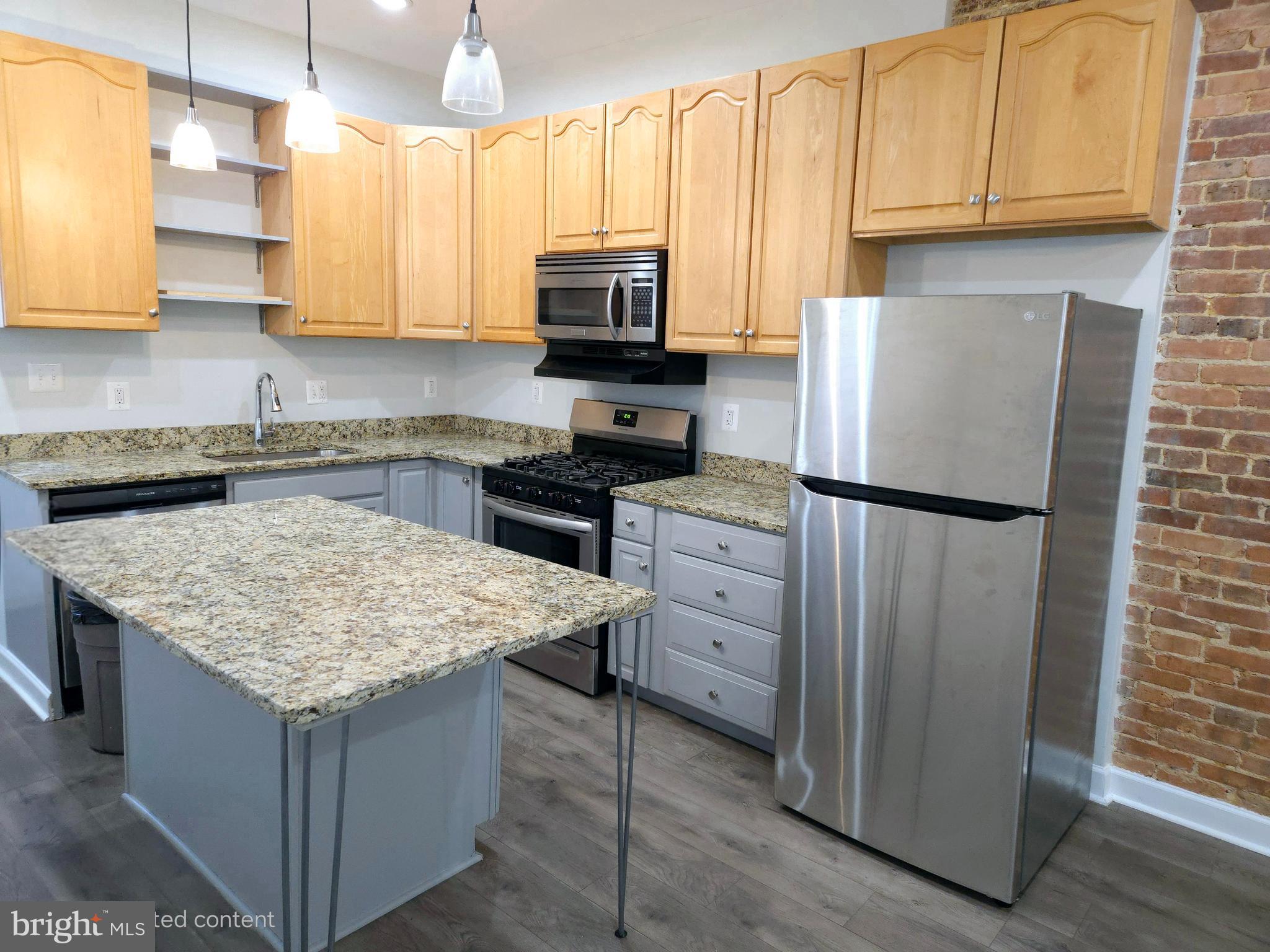 a kitchen with granite countertop a sink stove and refrigerator