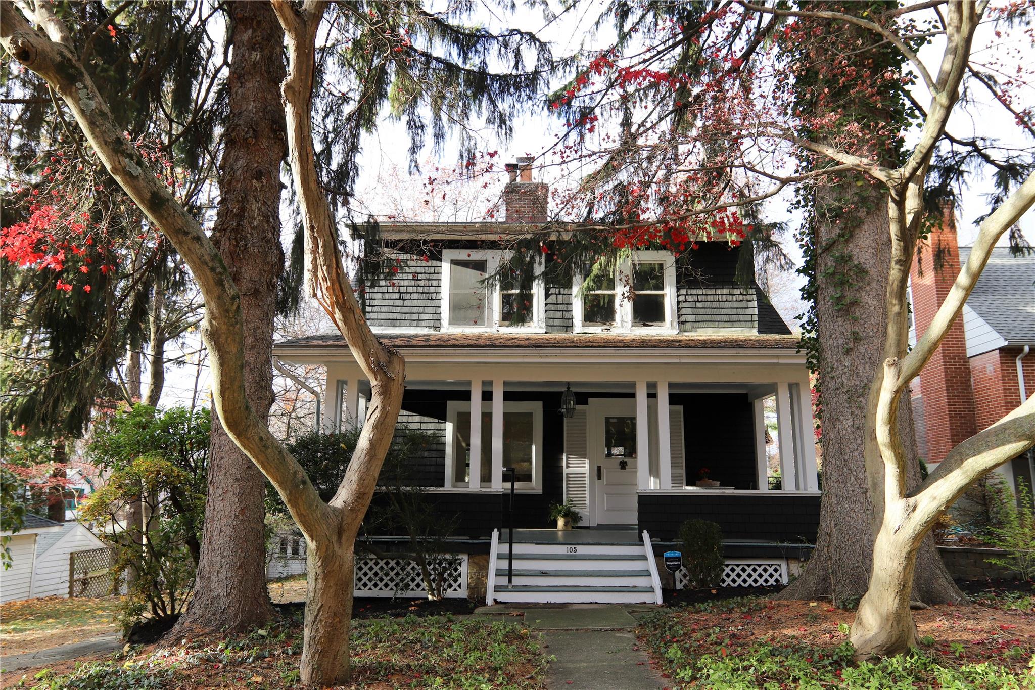 a front view of a house with a tree