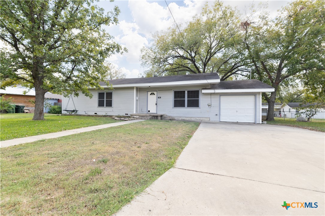 a view of a house with a yard and large tree