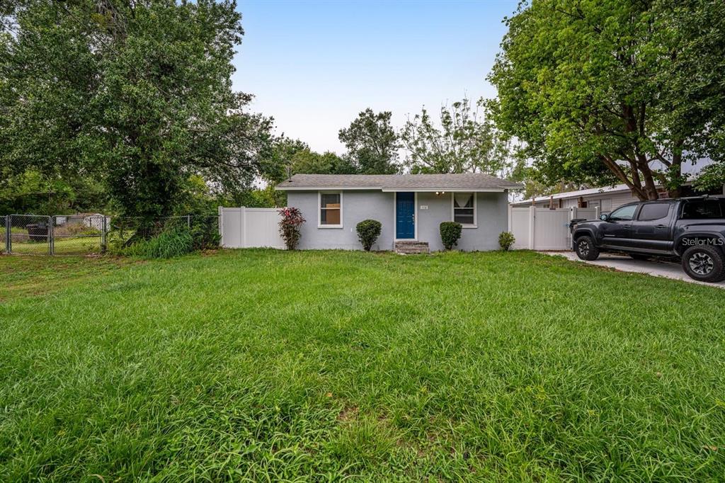 a view of a house with a yard and sitting area