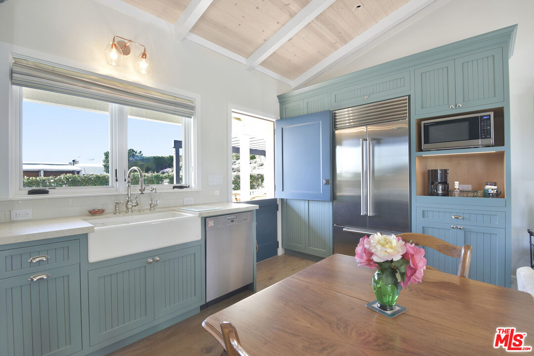 a kitchen with stainless steel appliances granite countertop a sink and a refrigerator