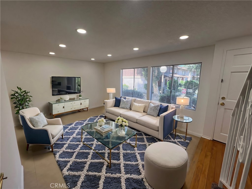 a living room with furniture a flat screen tv and a table