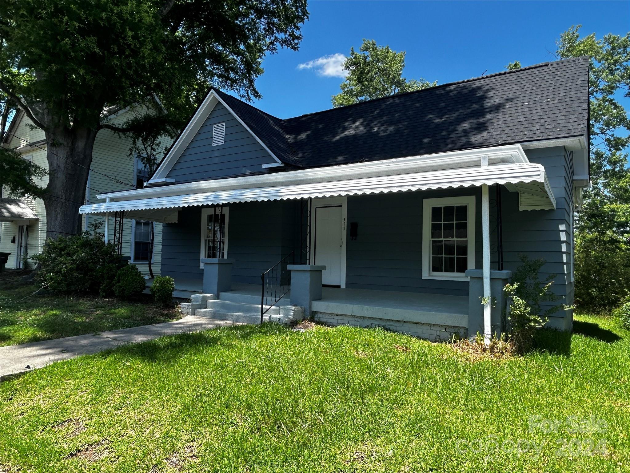 a front view of house with yard and outdoor seating