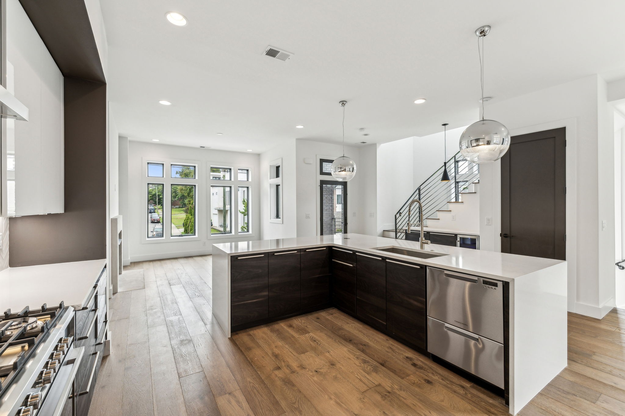 a large kitchen with stainless steel appliances kitchen island granite countertop a sink and wooden floor